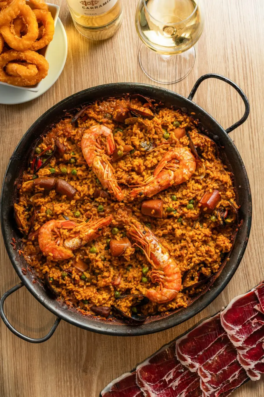 Paella served in a traditional pan to share, a cultural symbol of Spanish gastronomy.