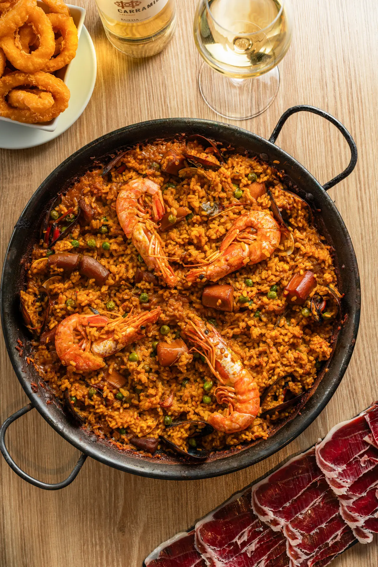 Paella servita in una padella tradizionale da condividere, simbolo culturale della gastronomia spagnola.
